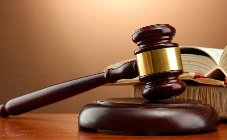 wooden gavel and books on wooden table,on brown background